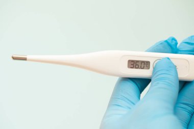 Eldivenli bir kız elinde termometre tutuyor. Sağlık hizmetleri kavramı.