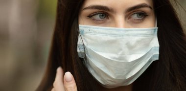 COVID-19 Salgın Kordemik Coronavirüs Kadın. Hastalık virüsü yaymak için maske takıyor. Coronavirus Hastalığı 2019 'a karşı koruyucu maskeli bir kız..
