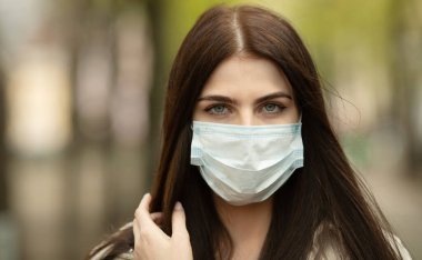 COVID-19 Salgın Kordemik Coronavirüs Kadın. Hastalık virüsü yaymak için maske takıyor. Coronavirus Hastalığı 2019 'a karşı koruyucu maskeli bir kız..