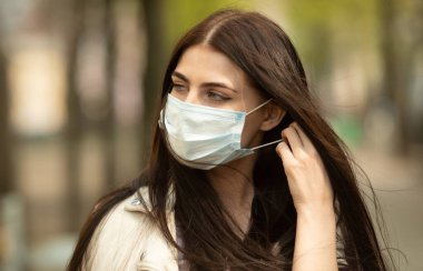 COVID-19 Salgın Kordemik Coronavirüs Kadın. Hastalık virüsü yaymak için maske takıyor. Coronavirus Hastalığı 2019 'a karşı koruyucu maskeli bir kız..