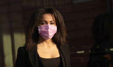 Maskeli kadın, grip virüsüne karşı koruma. Korunmak için maske takan Afro-Amerikalı bir kadın. Kadın dışarıda koruyucu yüz maskesi takıyor. Covid-19. Coronavirüs.