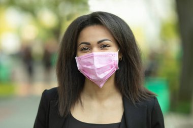Maskeli kadın, grip virüsüne karşı koruma. Korunmak için maske takan Afro-Amerikalı bir kadın. Kadın dışarıda koruyucu yüz maskesi takıyor. Covid-19. Coronavirüs.
