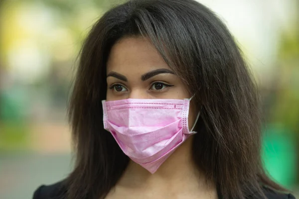 Masked woman - protection against influenza virus. African - American woman wearing mask for protect. Woman wear with protective face mask outdoor. Covid-19. Coronavirus.