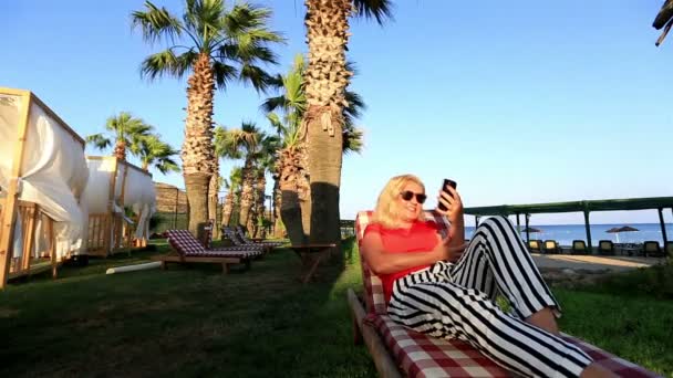 Блондинка проводит видеоконференцию со смартфоном — стоковое видео
