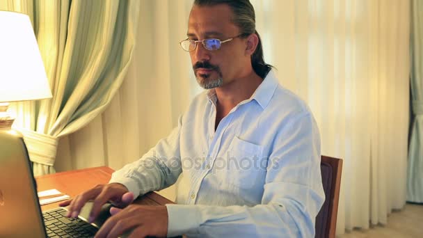 Середнього віку привабливий красивий чоловік використовує ноутбук — стокове відео