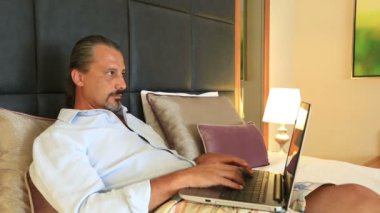 Orta yaş çekici yakışıklı dizüstü bilgisayar kullanarak