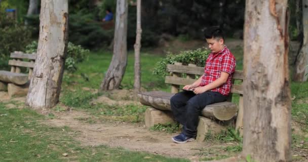 Portrait d'un adolescent caucasien avec tablette numérique à la nature — Video