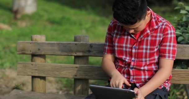 Retrato de un adolescente caucásico con tableta digital en la naturaleza — Vídeo de stock