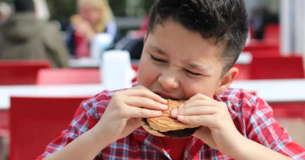 Barn äter hamburgare på restaurangen — Stockvideo