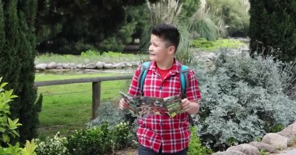 Joven viajero feliz con mapa caminando en la naturaleza verde — Vídeo de stock