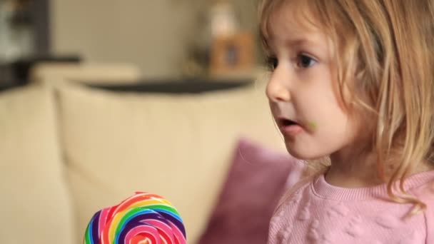 Menina bonito com doces assistindo tv — Vídeo de Stock
