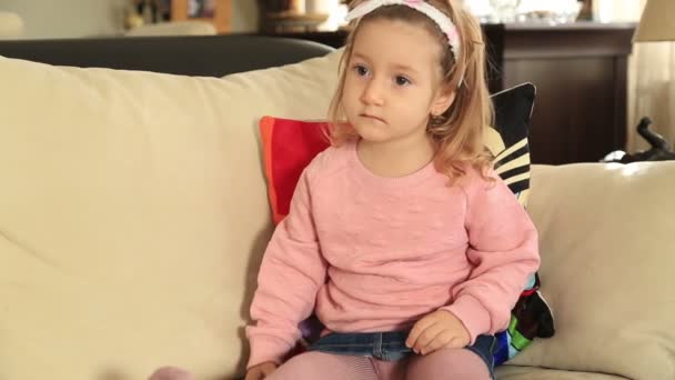 Маленька дівчинка дивиться телевізор — стокове відео
