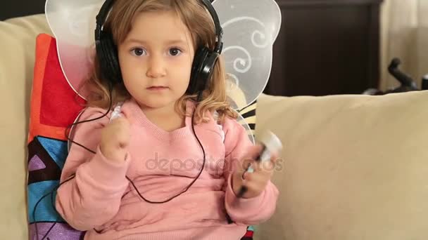 Porträtt av en söt liten flicka som lyssnar på musik — Stockvideo