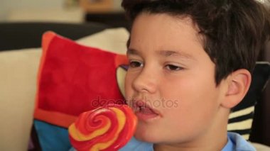 Büyük renkli lolipop şeker ile genç şirin çocuk