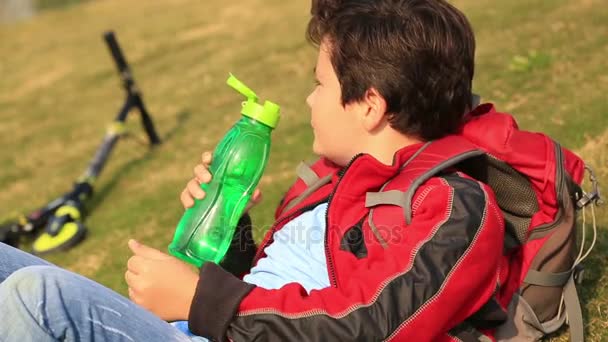 Jeune garçon buvant de l'eau d'une bouteille — Video