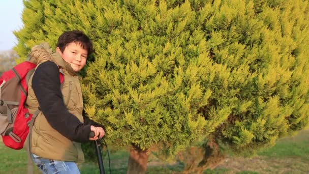 Jonge jongen rijden van scooters in park, kids sport — Stockvideo