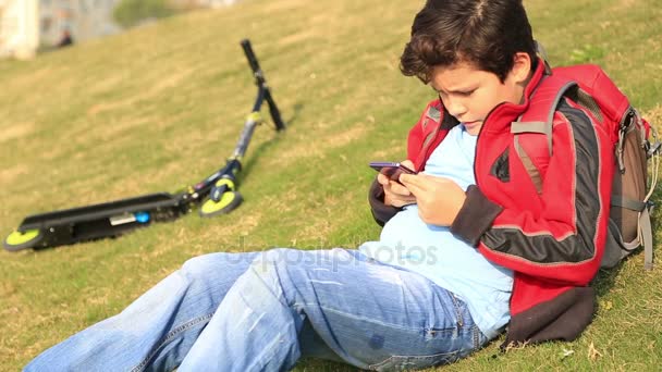 Мальчик с помощью смартфона на открытом воздухе — стоковое видео
