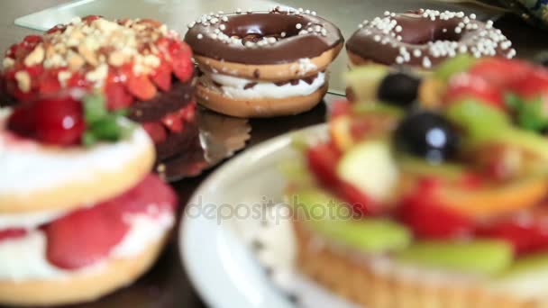 Deliciosa torta com bolos de frutas frescas e donuts — Vídeo de Stock