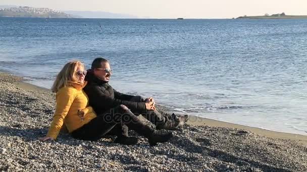Gelukkige paar ontspannen op het strand van de winter — Stockvideo