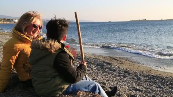 Мать и сын отдыхают на зимнем пляже — стоковое видео