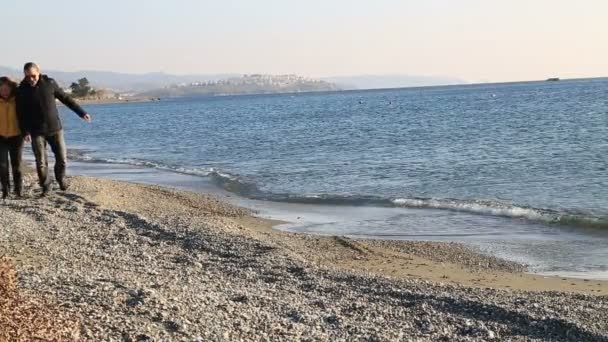 Familia relajada caminando en la playa de invierno — Vídeos de Stock