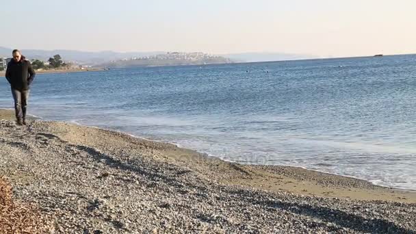 Entspannter Mann geht am Strand spazieren — Stockvideo