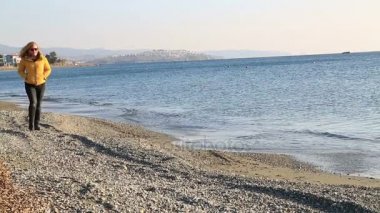 Kumsalda yürüyen rahat kadın