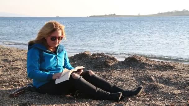 Mujer leyendo un libro en la playa 2 — Vídeo de stock