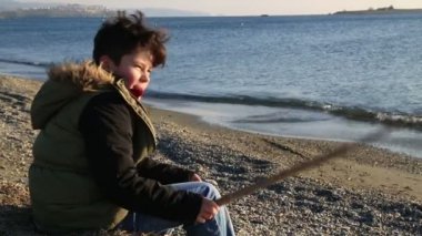 Genç çocuk deniz kenarında rahatlatıcı
