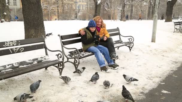 Mutter Mit Sohn Sitzt Auf Einer Parkbank Ein Verschneiter Wintertag — Stockvideo