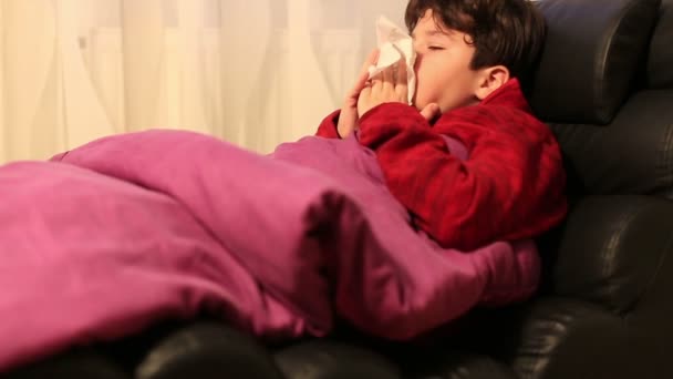 Niño Enfermo Gripe Con Ropa Abrigo Sonándose Nariz Acostado Sofá — Vídeo de stock
