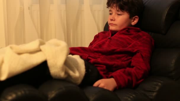 Çocuk bir koltukta yalan ve uyku uzaktan kumanda ile — Stok video