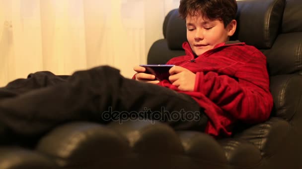 Niño Acostado Sofá Jugar Con Teléfono Inteligente Casa — Vídeos de Stock