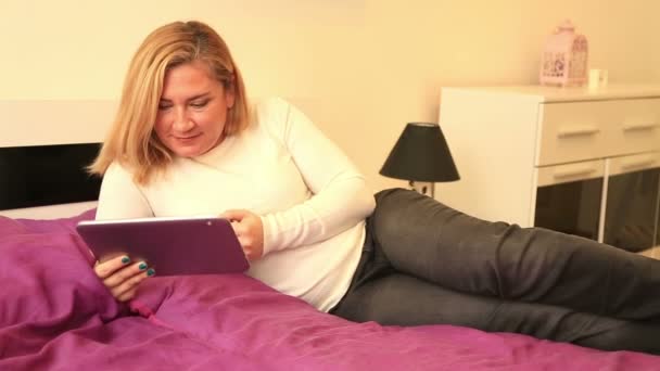 Mulher com tablet digital deitada na cama 2 — Vídeo de Stock