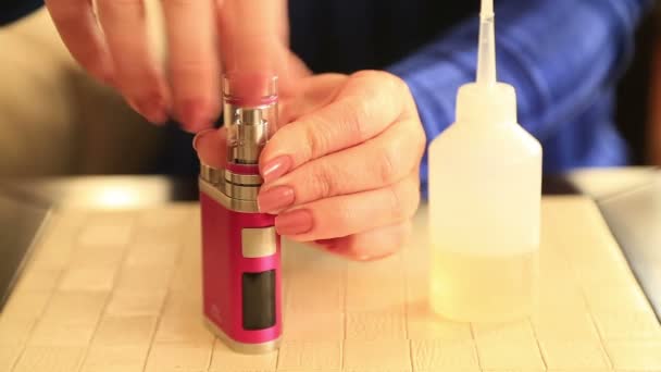 Woman hand prepares her e-cigarette — Stock Video