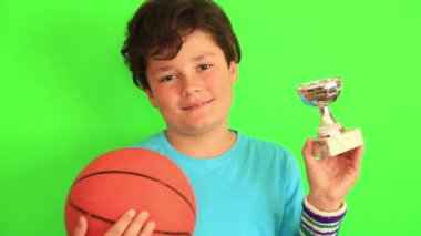 Basketbol topu ve şampiyon kupa tutan çocuk
