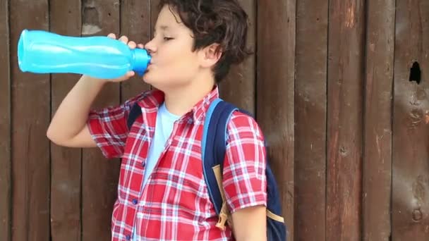 Jovem menino gotejando água de garrafa de plástico 2 — Vídeo de Stock