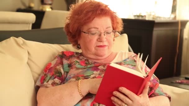 Senior woman reading a book at home 2 — Stock Video