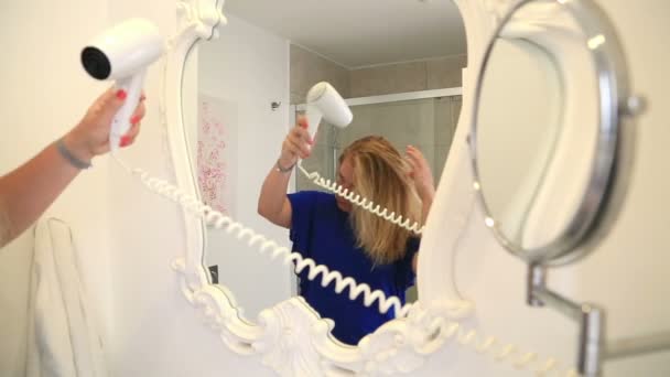 Женщина сушит волосы в ванной комнате 4 — стоковое видео