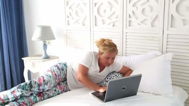 Woman laying on a bed using laptop 2 — Stock Video