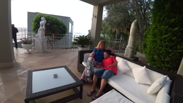 Mutter und Sohn sitzen im Garten — Stockvideo