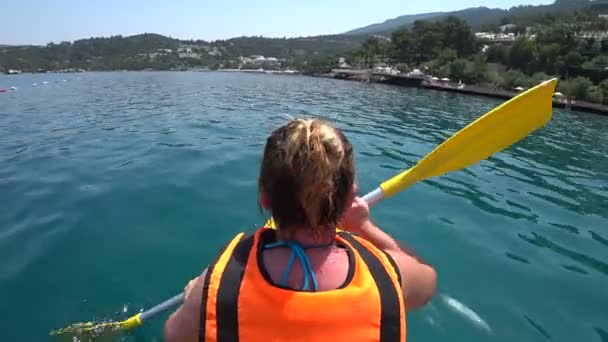 Mujer cabalgando en canoa en el mar — Vídeo de stock