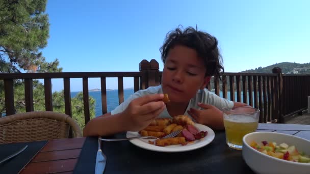 Handsome preteen eating breakfast at the outdoor — Stock Video
