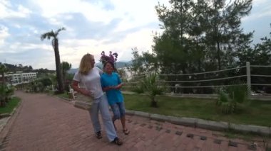 Anne ve oğlu deniz kıyısında günbatımı yürüyerek.
