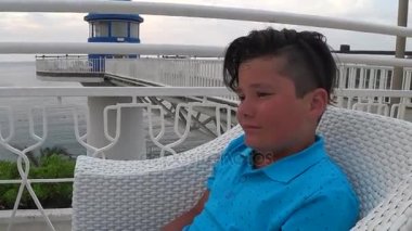 Young boy sitting at the outdoors 3
