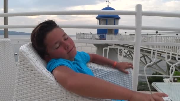 Молодий хлопчик сидить на відкритому повітрі 2 — стокове відео
