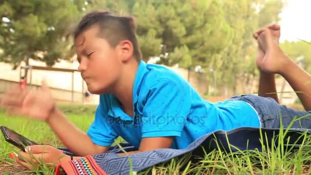 Teenage boy using smartphone at the outdoor — Stock Video