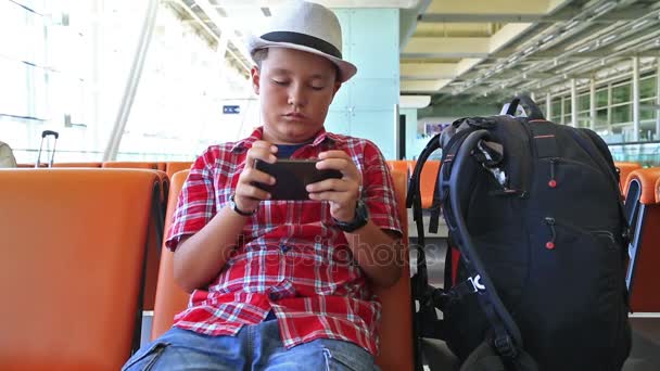 Menino adolescente usando smartphone no aeroporto — Vídeo de Stock