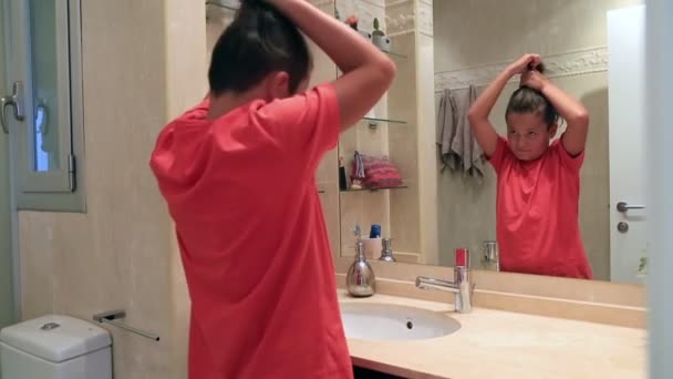 Teenage boy in front of the mirror brushing his hair — Stock Video