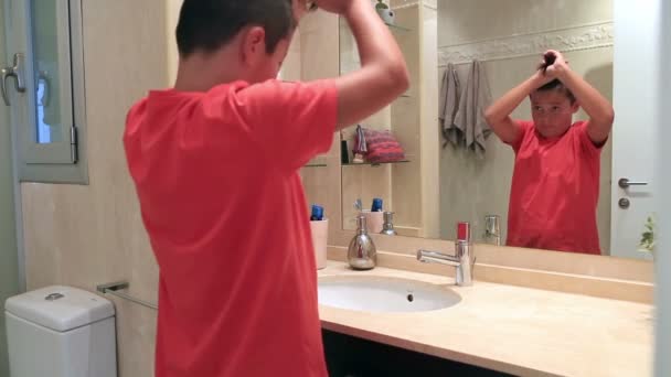 Teenege 男孩对着镜子梳理他的头发 — 图库视频影像